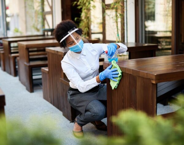 cafe-owner-cleaning-tables-with-disinfectant-while-reopening-covid19-pandemic_637285-8020